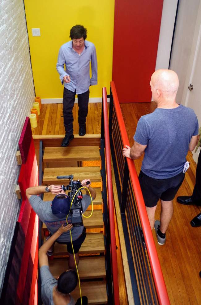Crew filming talent descending a staircase on set