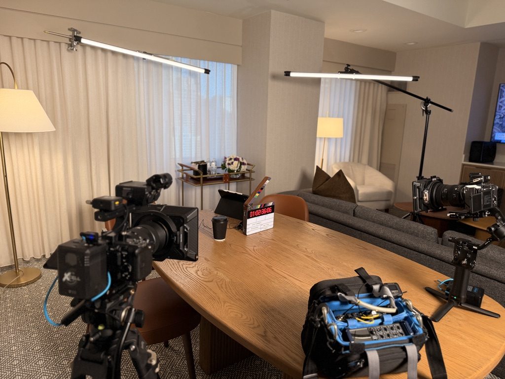 Two cameras set up facing a conference table ahead of an interview